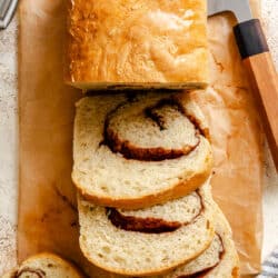 Three cut slices of cinnamon bread next to the loaf.
