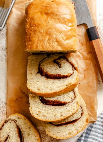 Three cut slices of cinnamon bread next to the loaf.