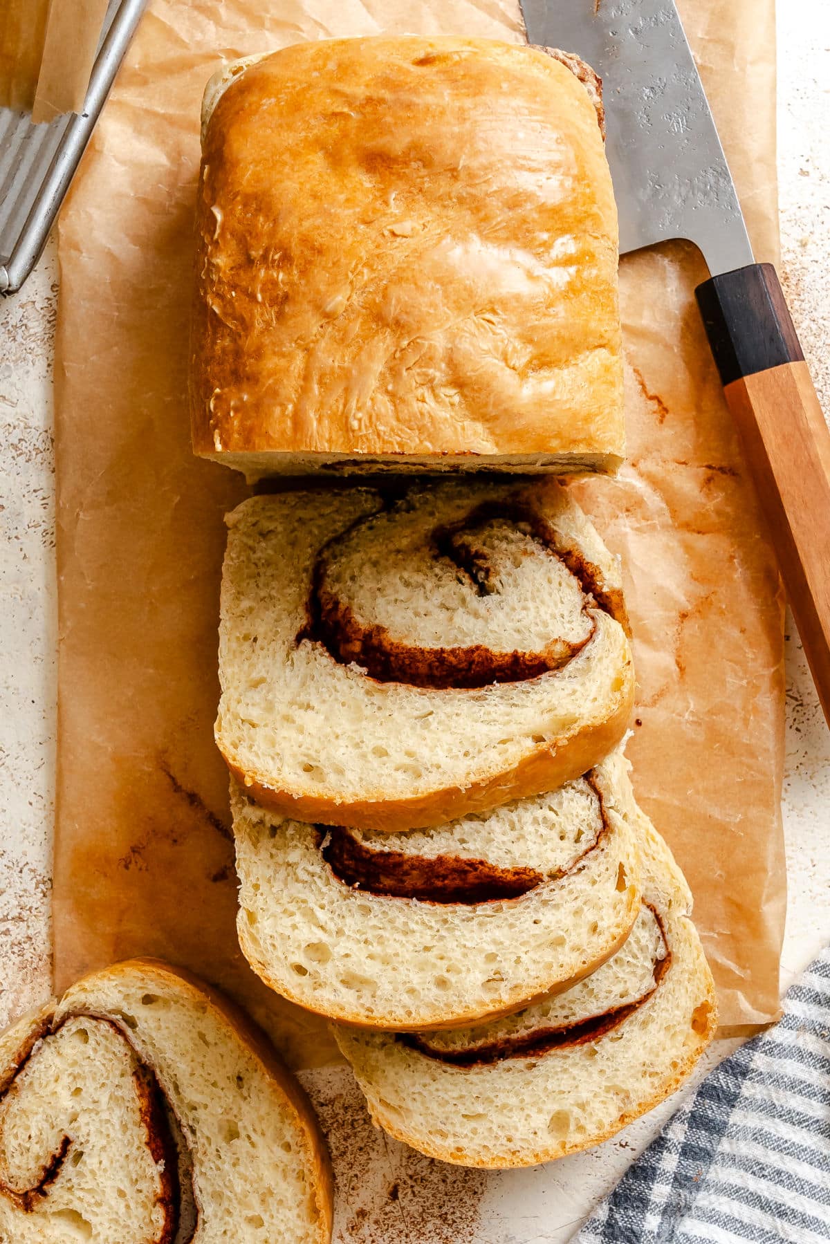 Three cut slices of cinnamon bread next to the loaf.