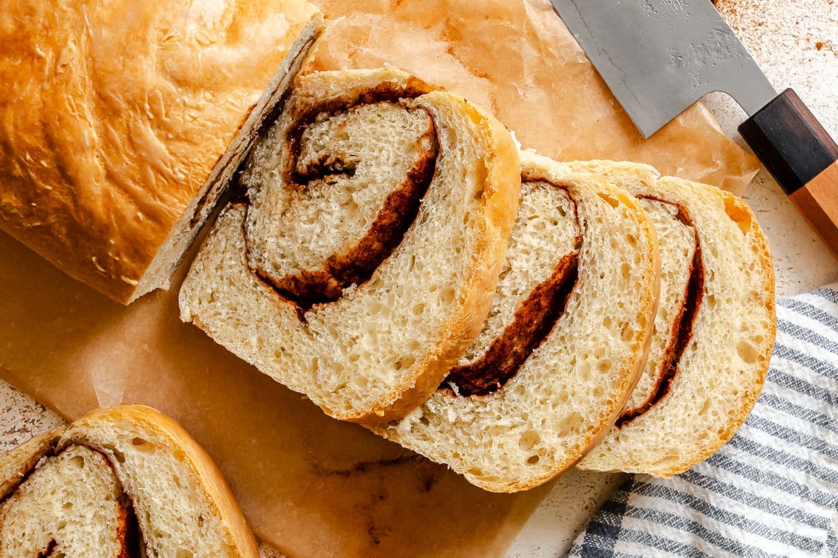 Slices of cinnamon swirl bread on a wooden cutting board. 