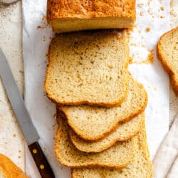 Slices of bread machine honey oat bread next to the partially cut loaf.