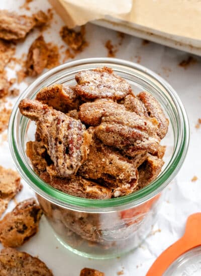Homemade candied pecans in a glass jar.