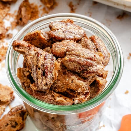 Homemade candied pecans in a glass jar.