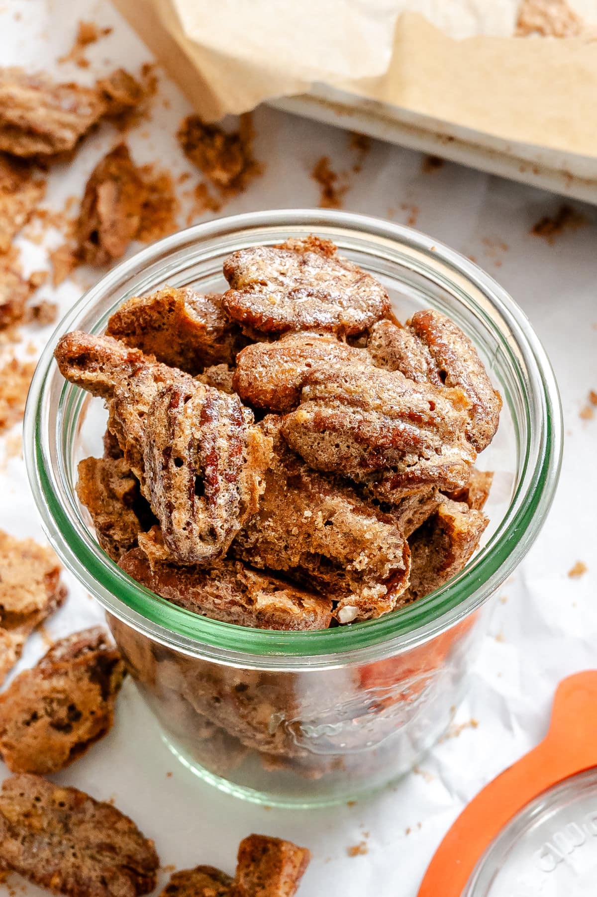 Homemade candied pecans in a glass jar.