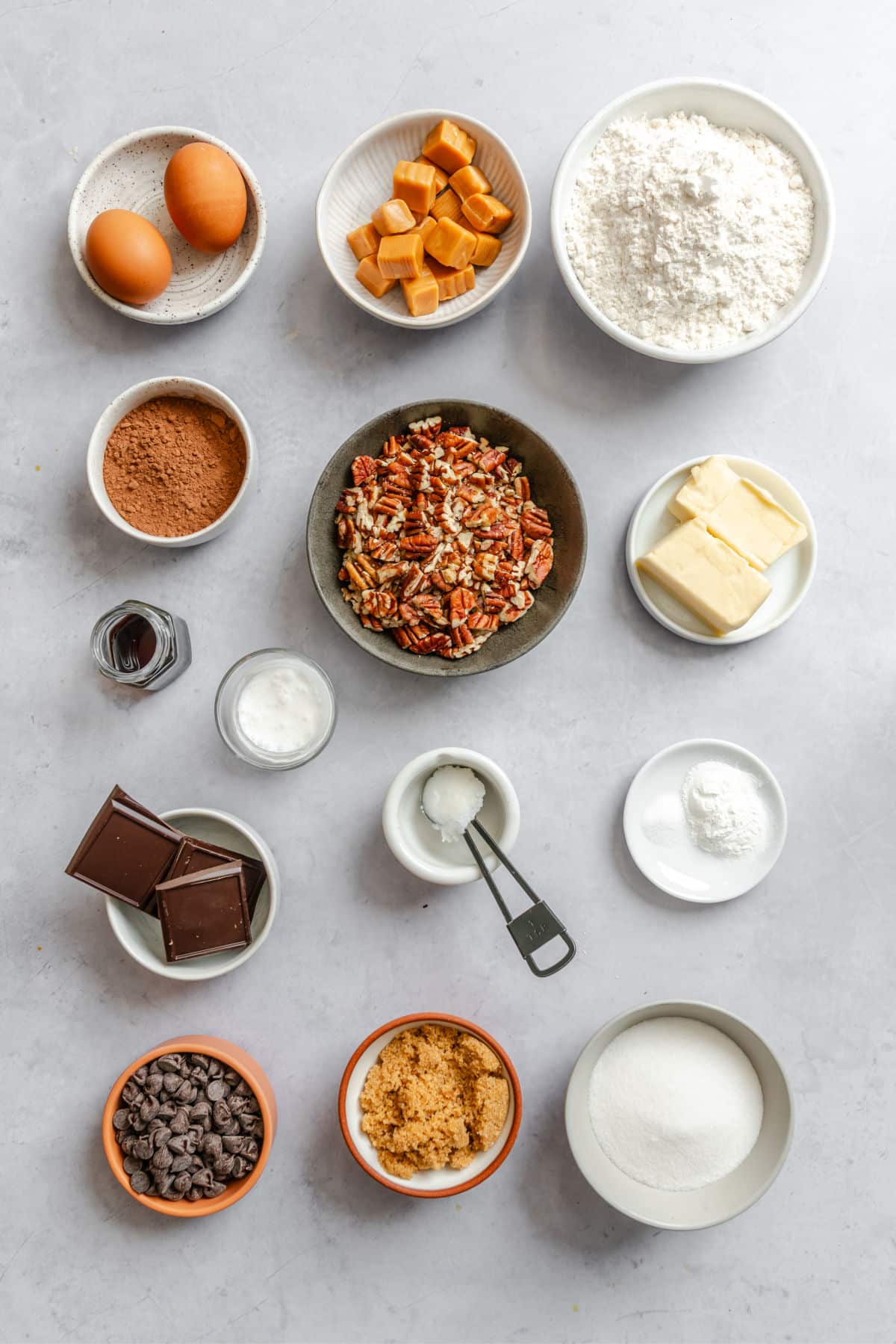 Ingredients for chocolate caramel thumbprint cookies in dishes. 