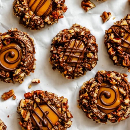 Chocolate caramel thumbprint cookies next to unwrapped caramels.