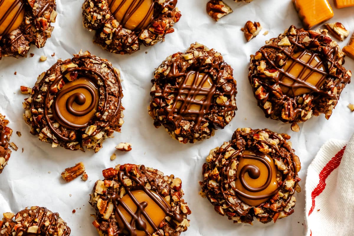 Chocolate caramel thumbprint cookies next to unwrapped caramels. 