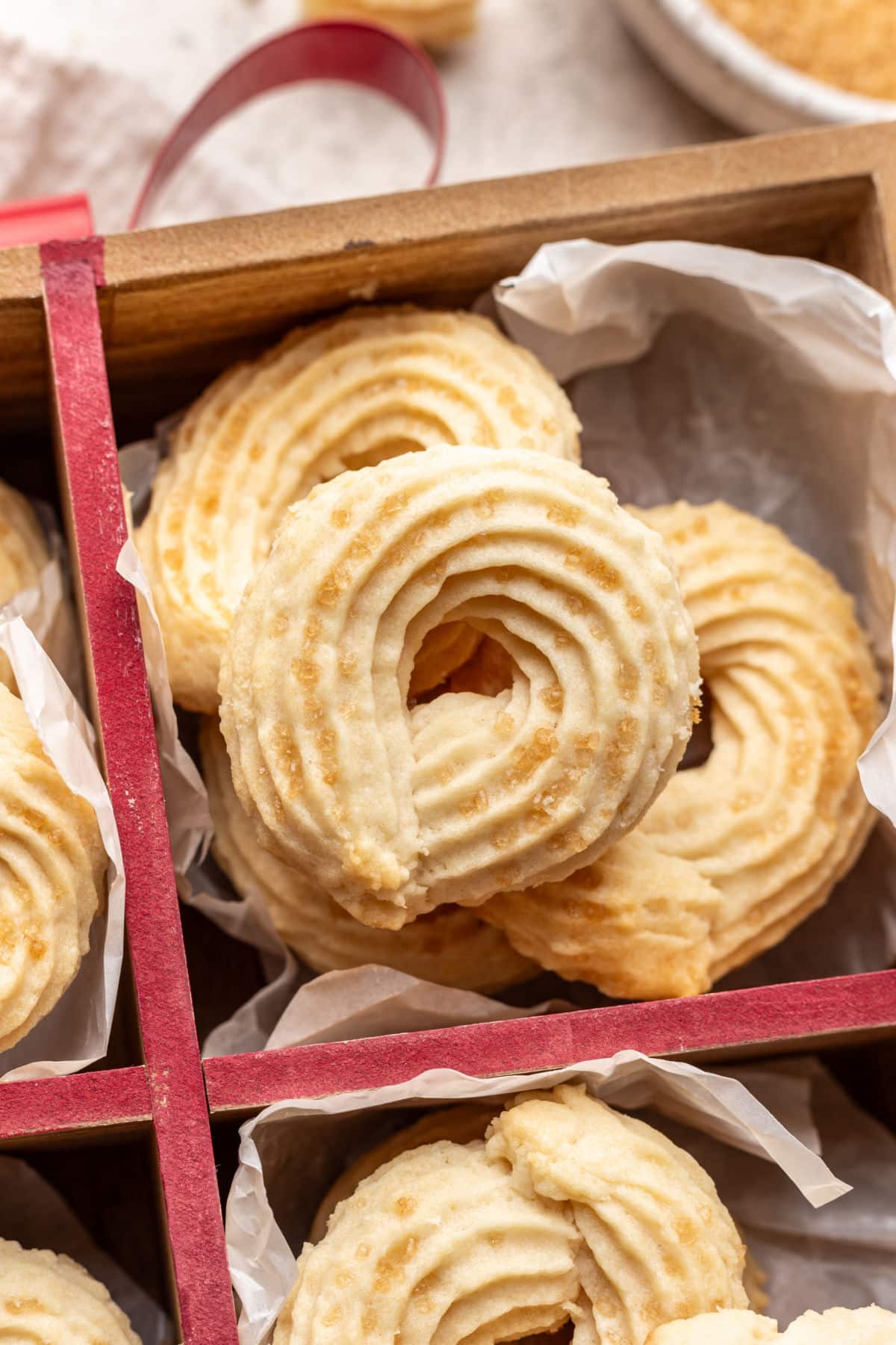 Three overlapping Danish butter cookies in a ribbon tied box.