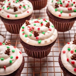 Decorated gingerbread cupcakes on a wire cooling rack.