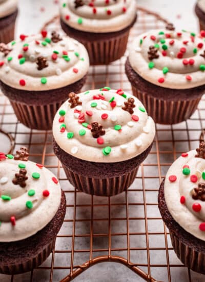 Decorated gingerbread cupcakes on a wire cooling rack.