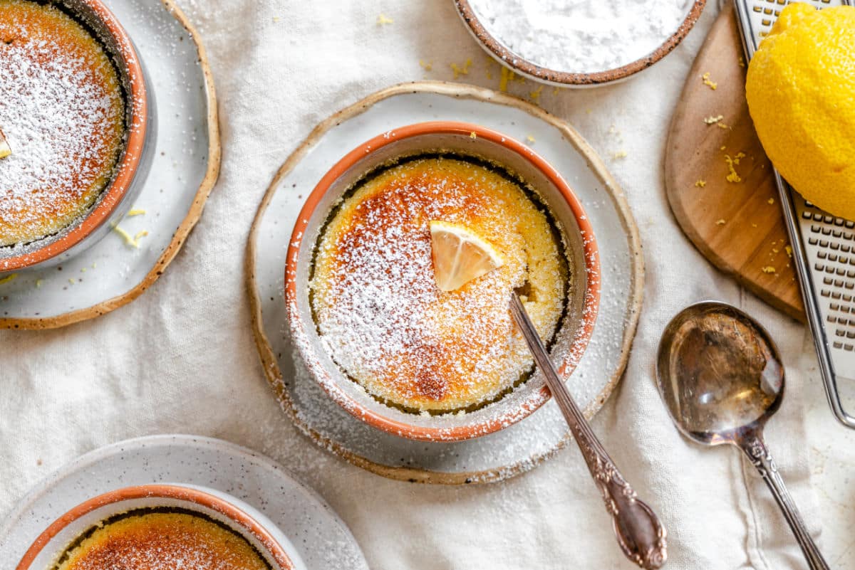 Lemon pudding cakes in ramekins dusted with powdered sugar. 