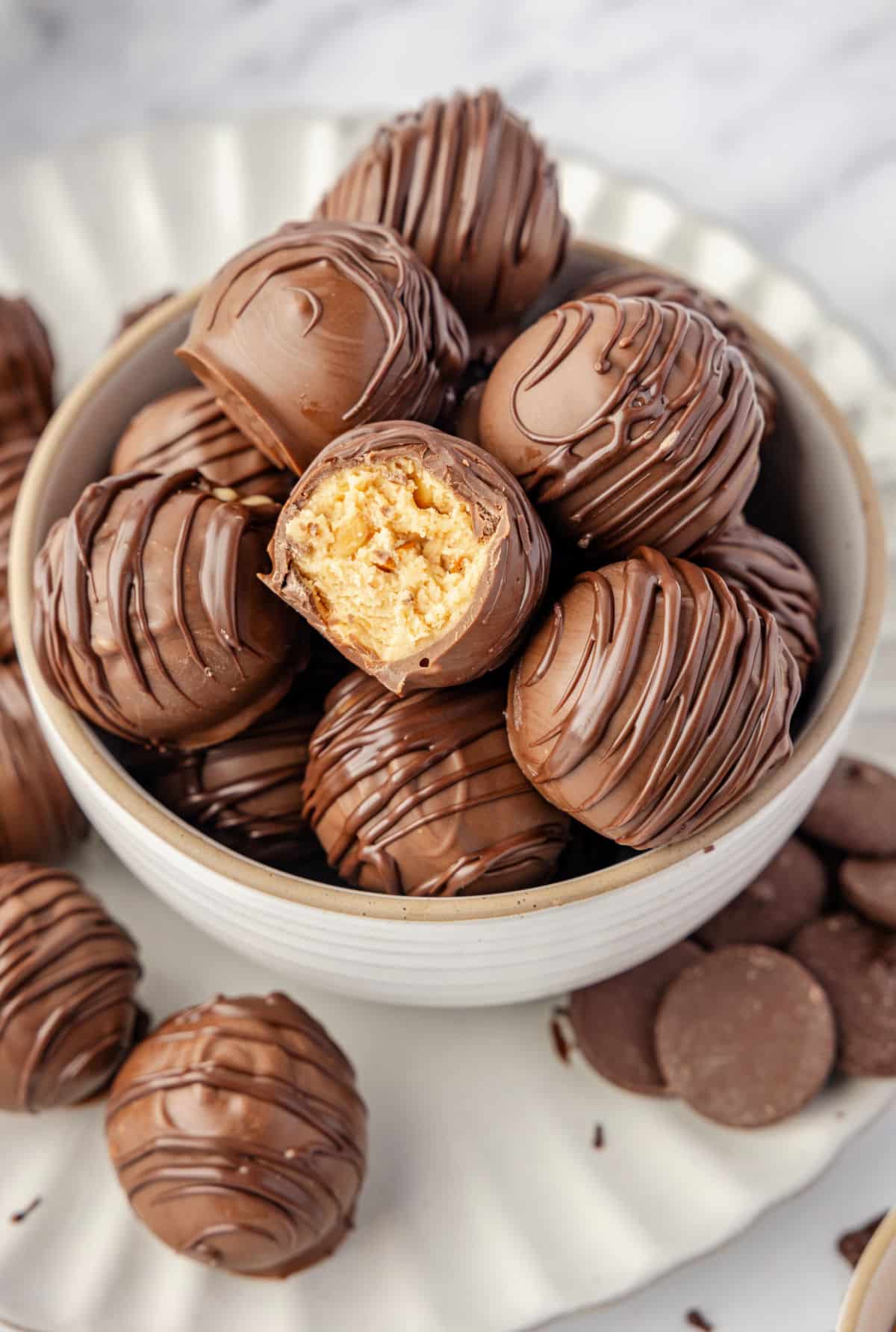 A bowl filled with peanut butter balls on a white plate.