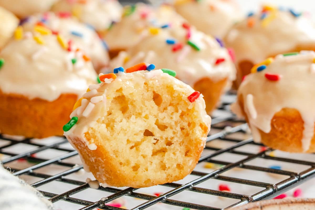 A baked sugar cookie donut hole with a bite taken out of it. 