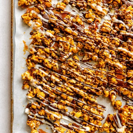 Homemade zebra popcorn on a parchment lined baking sheet.