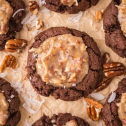Rows of German chocolate thumbprint cookies on brown parchment paper.
