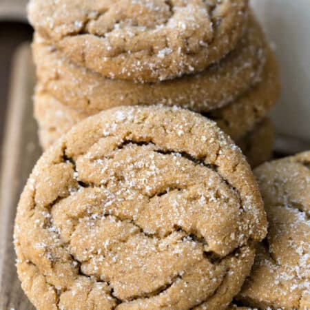 A soft ginger molasses cookie leaning against a stack of cookies.