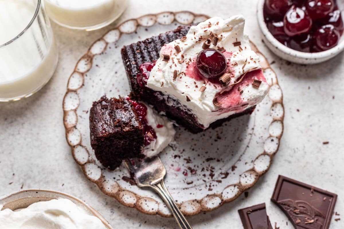 A piece of Black Forest sheet cake with a bite on a fork. 