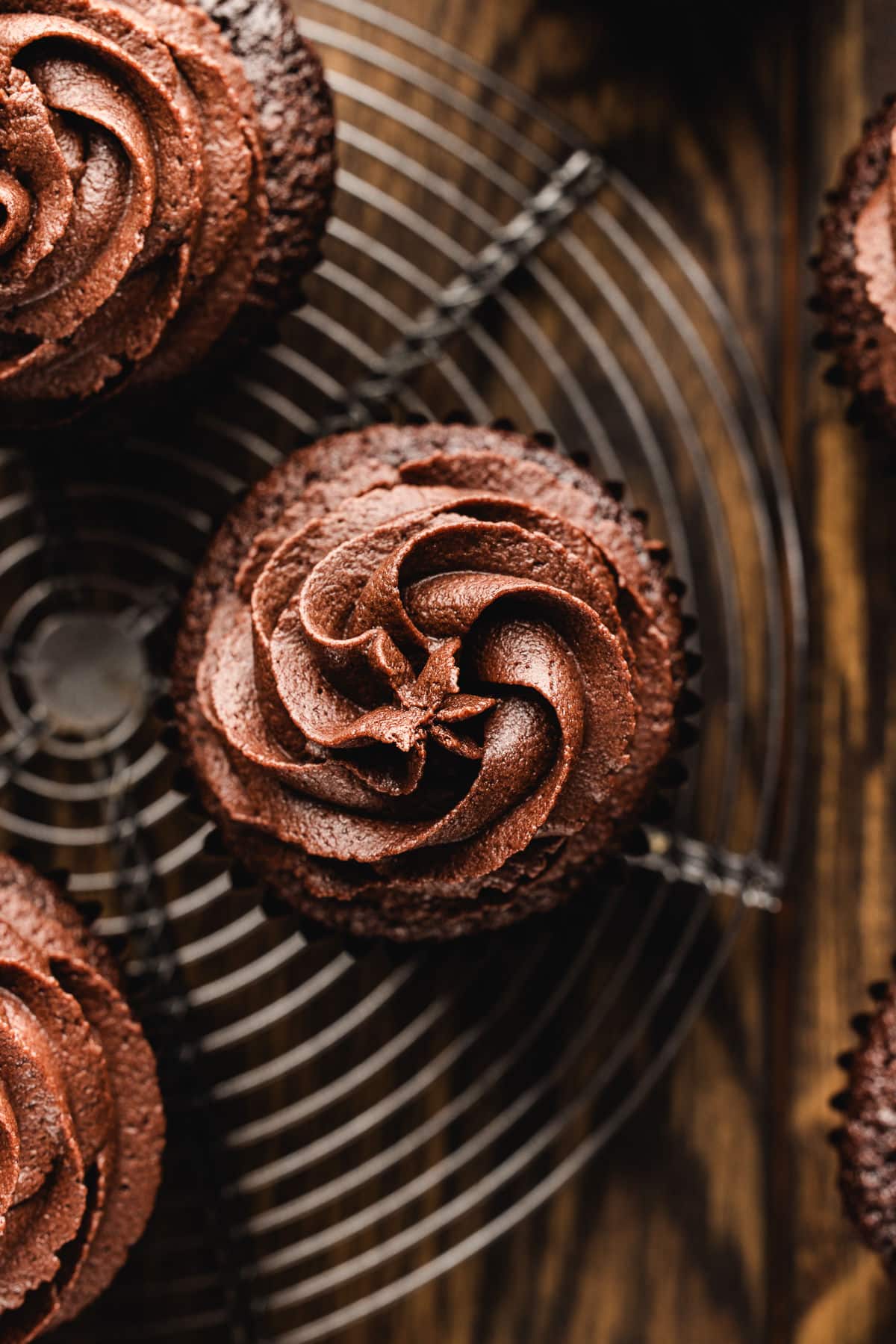 Overhead view of chocolate cupcakes with swirled chocolate buttercream frosting. 