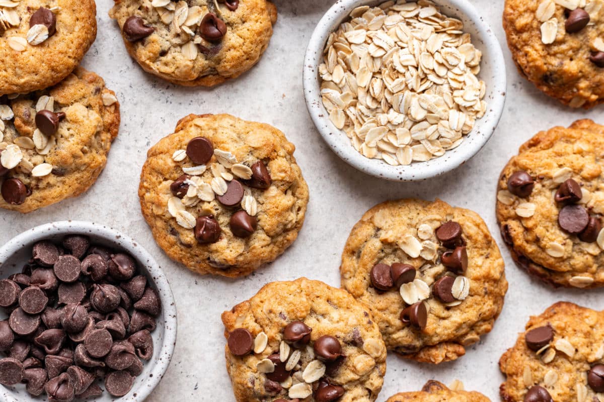 Banana oatmeal cookies overlapping next to dishes of oats and chocolate chips.