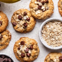 Banana oatmeal cookies next to dishes of oats and chocolate chips.