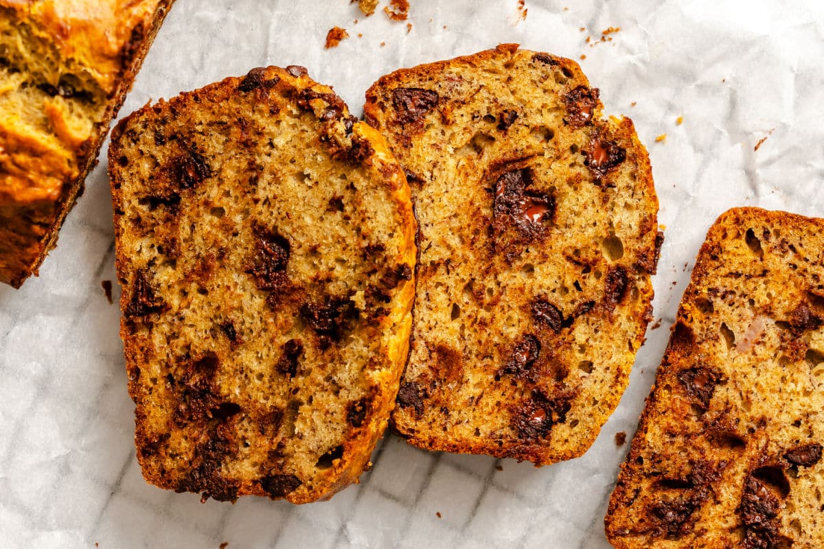 Slices of chocolate chip banana bread on white parchment paper. 