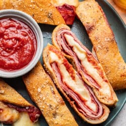 Slices of stromboli on a plate with two slices cut side up.