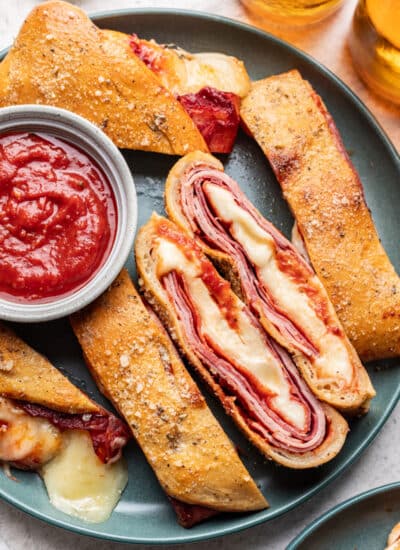 Slices of stromboli on a plate with two slices cut side up.