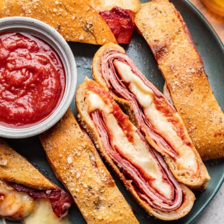 Slices of stromboli on a plate with two slices cut side up.