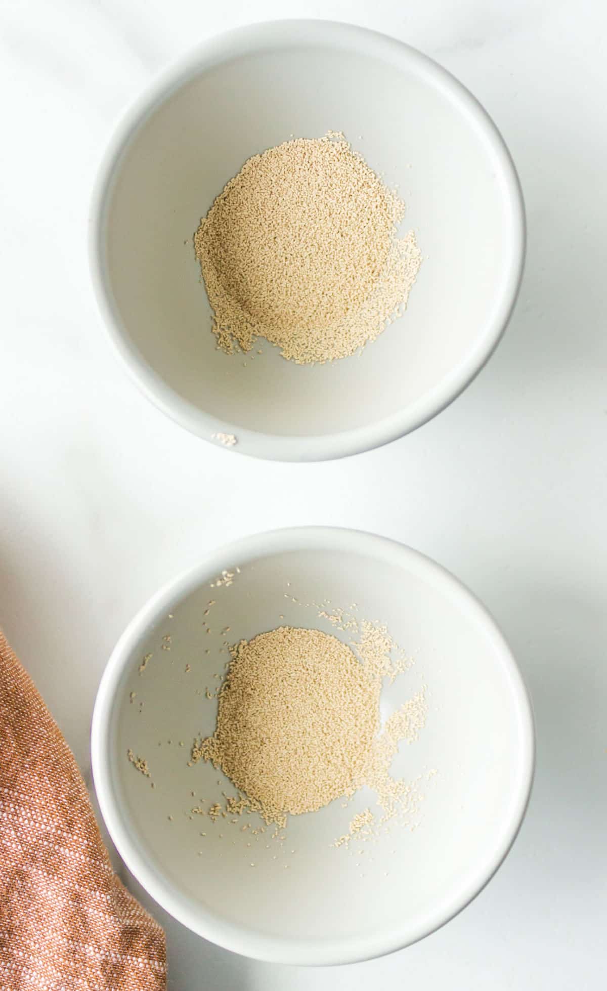 Two bowls of different types of yeast next to each other.