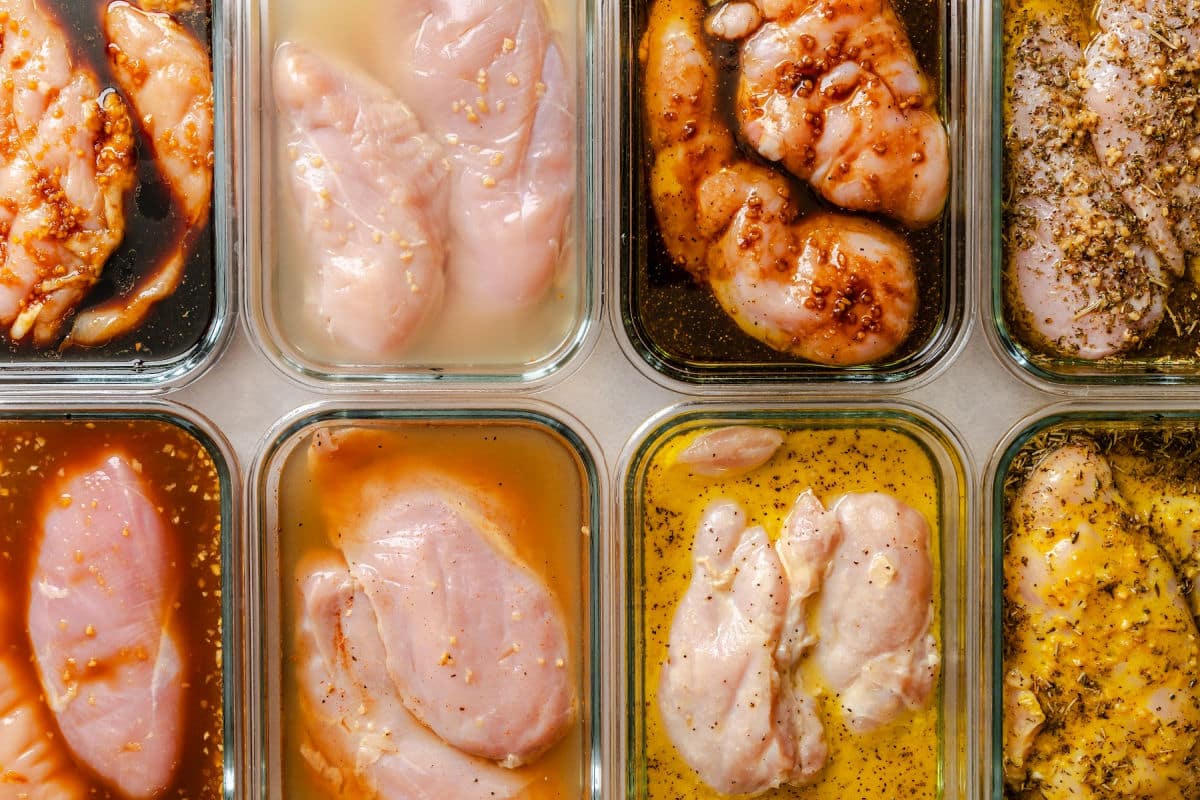 Two pieces of chicken each in 8 marinade dishes.