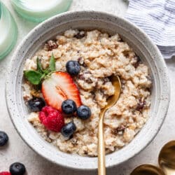 A bowl of baked rice pudding topped with fresh berries.