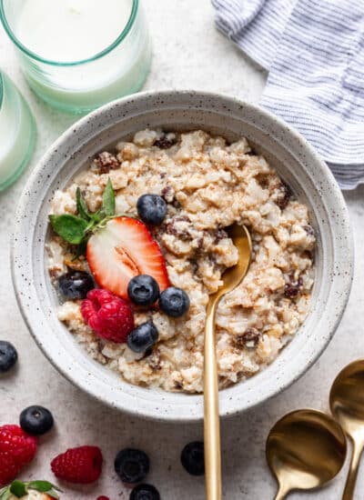A bowl of baked rice pudding topped with fresh berries.