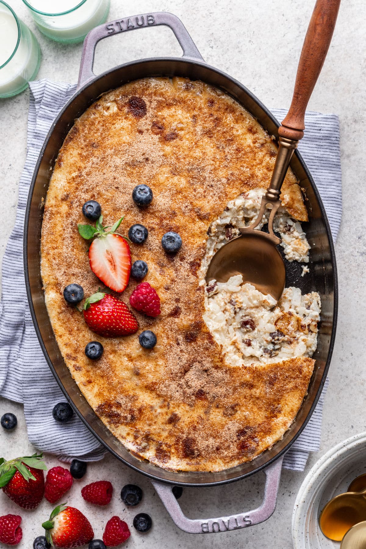 A pan of baked rice pudding topped with fresh berries.