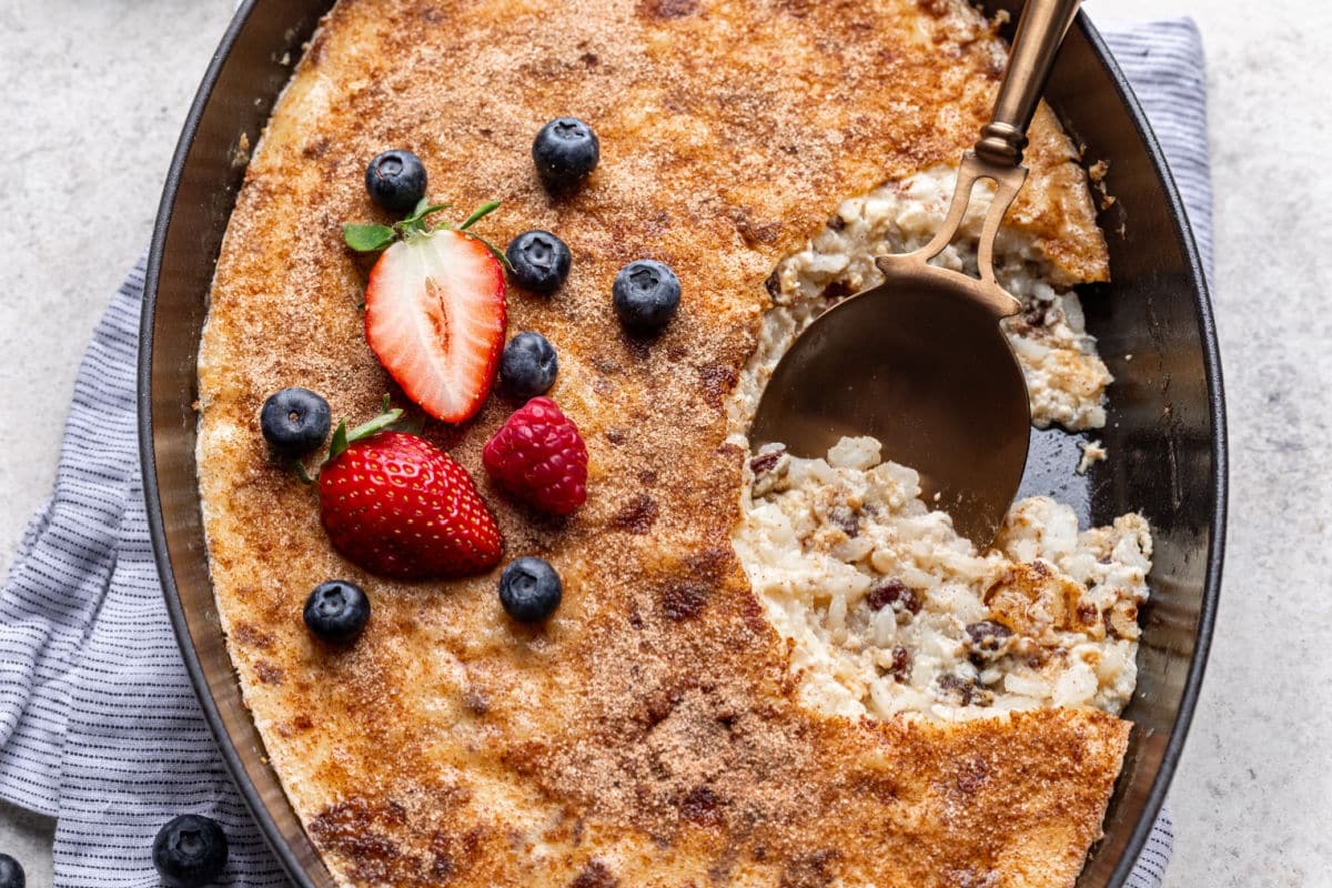 A pan of baked rice pudding with spoon in it.