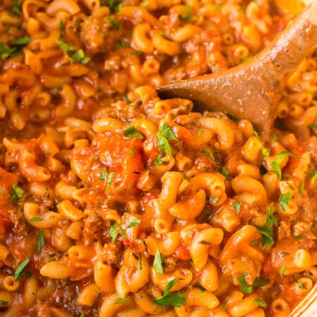 A wooden spoon in a pot of homemade hamburger helper.