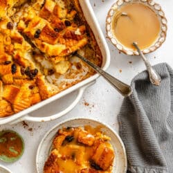 A plate of Irish bread pudding topped with sauce next to the pan.