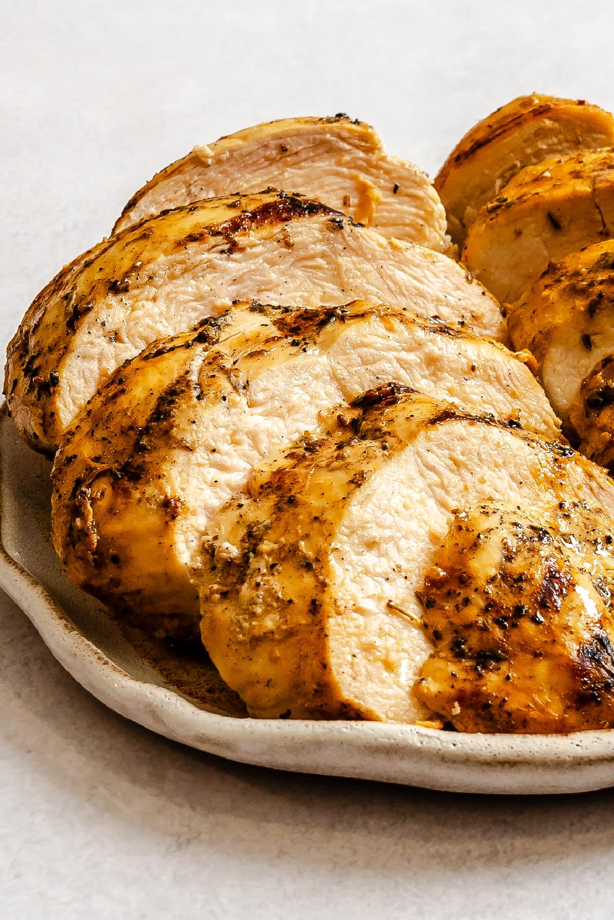 Poulet mariné aux herbes et à la moutarde grillé sur une assiette.