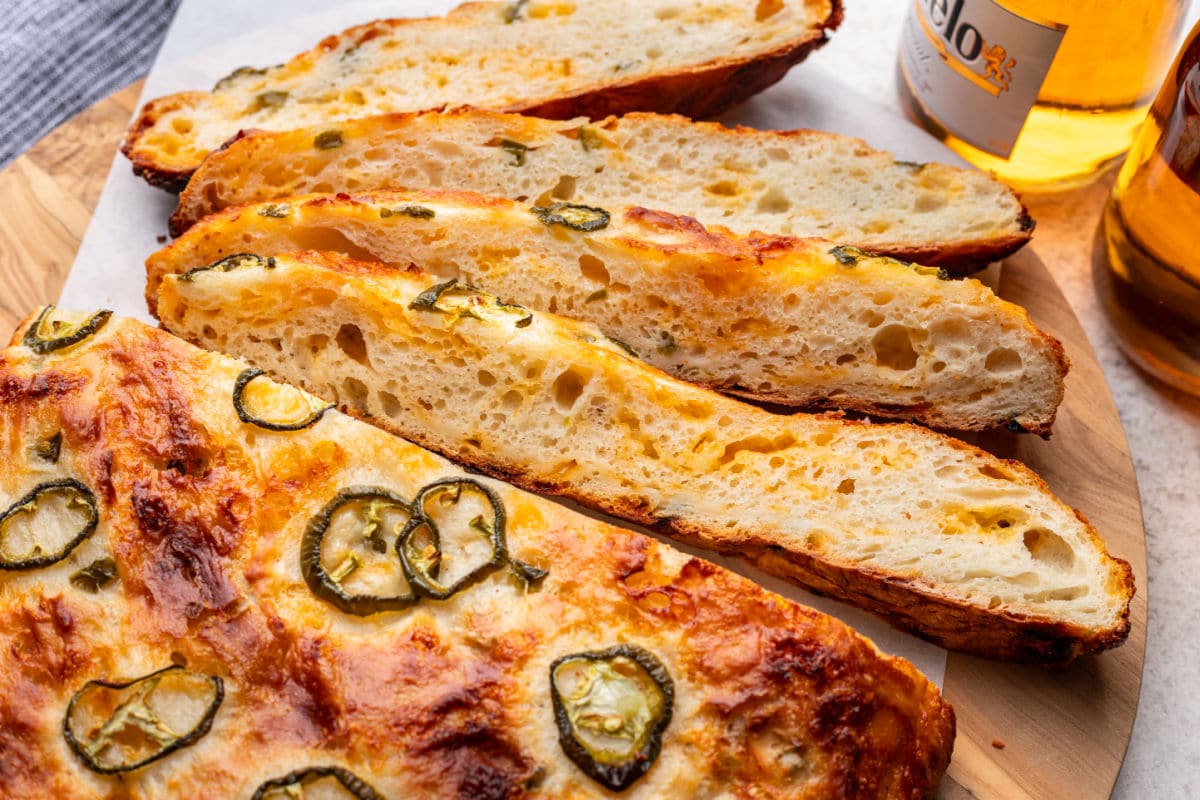 Four slices of no knead cheddar jalapeno bread on a cutting board. 