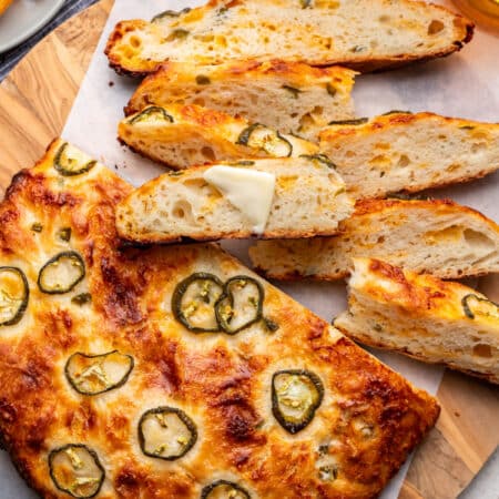 Slices of no knead cheddar jalapeno bread next to the rest of the loaf.
