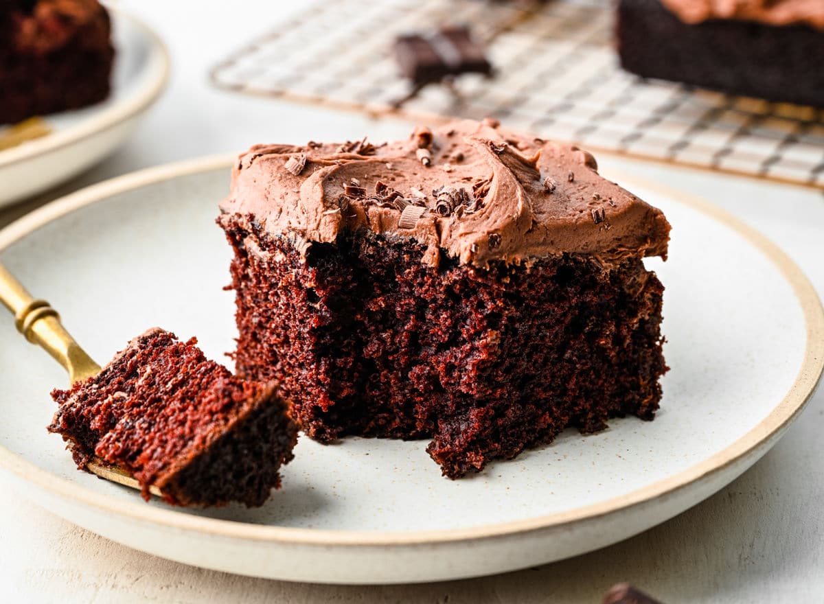 A slice of chocolate wacky cake with a bite on a fork. 