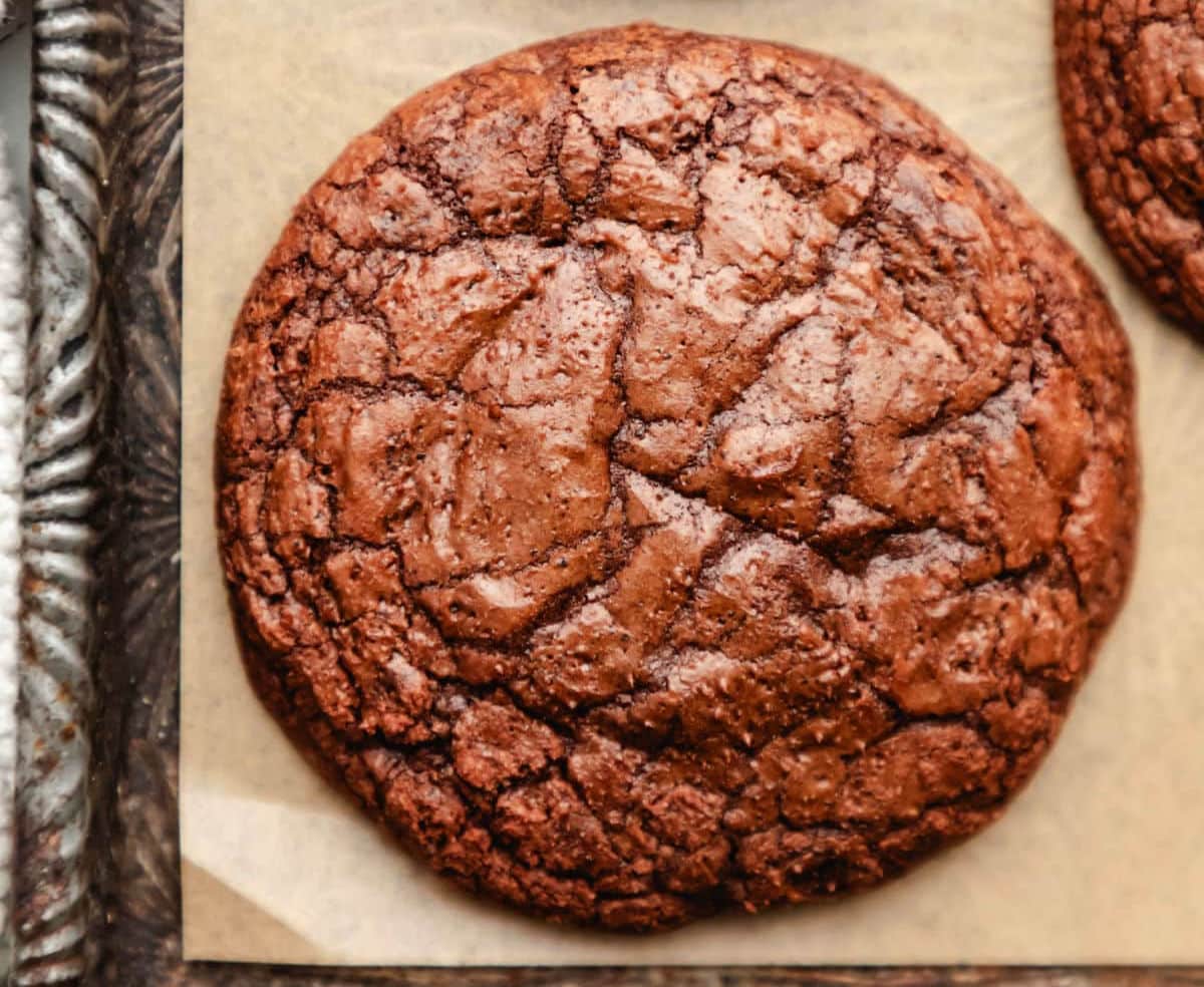 A brownie cookie at the bottom edge of a vintage baking sheet. 