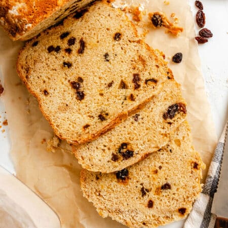 Three slices of bread machine Irish soda bread next to the loaf.