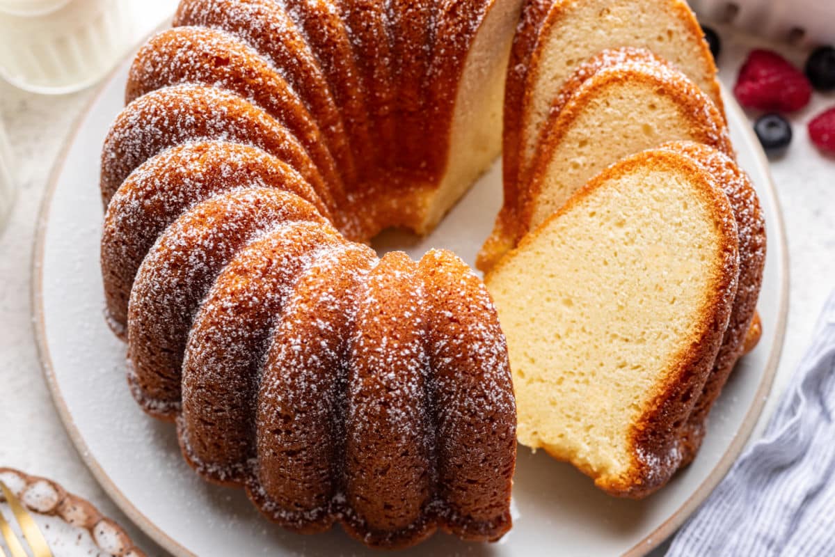 Slices of cream cheese pound cake leaning against the cake.