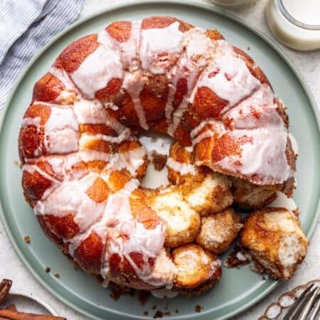 Monkey bread on a green plate with a few pieces missing.