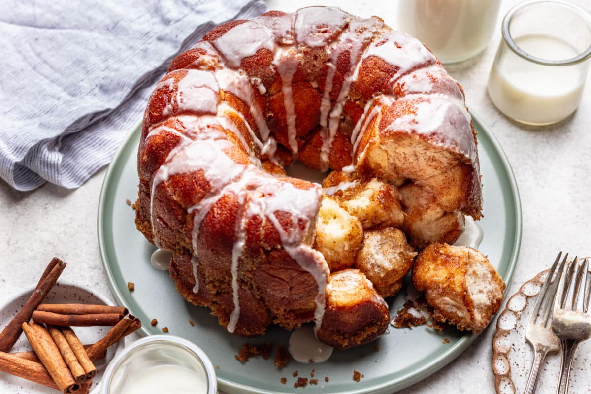 Monkey Bread Recipe A plate of monkey bread with some pieces missing next and sitting next to it.