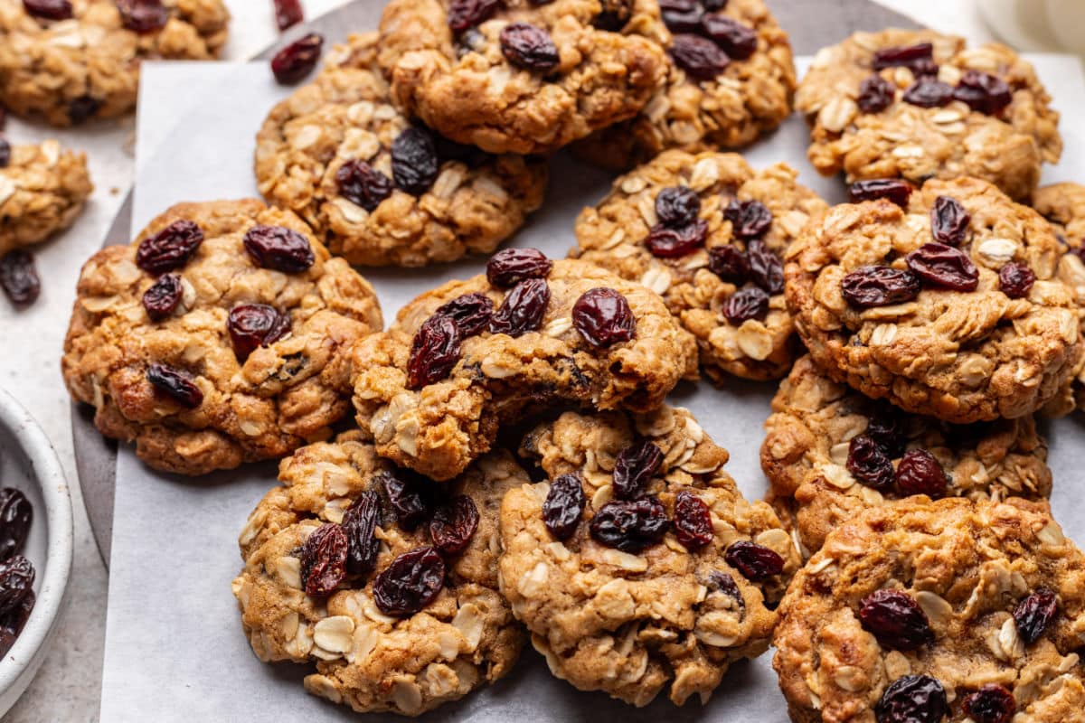 A brown butter oatmeal raisin cookie on top of overlapping cookies. 