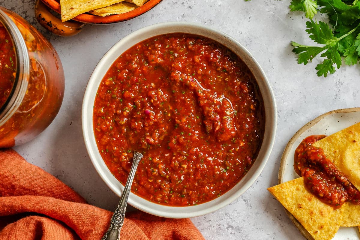 A dish of blender salsa with a spoon in it. 