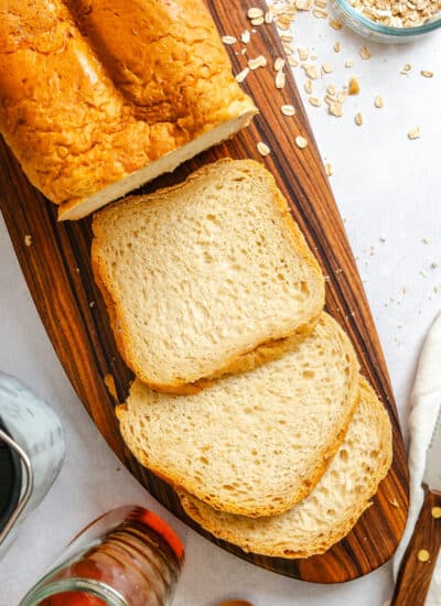 Three slices of bread machine buttermilk oat bread next to the loaf.