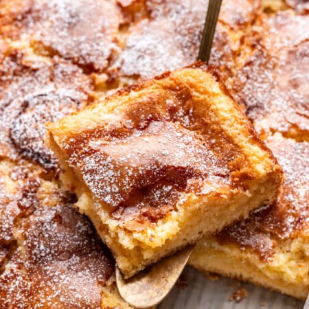 A slice of gooey butter cake on a cake server.