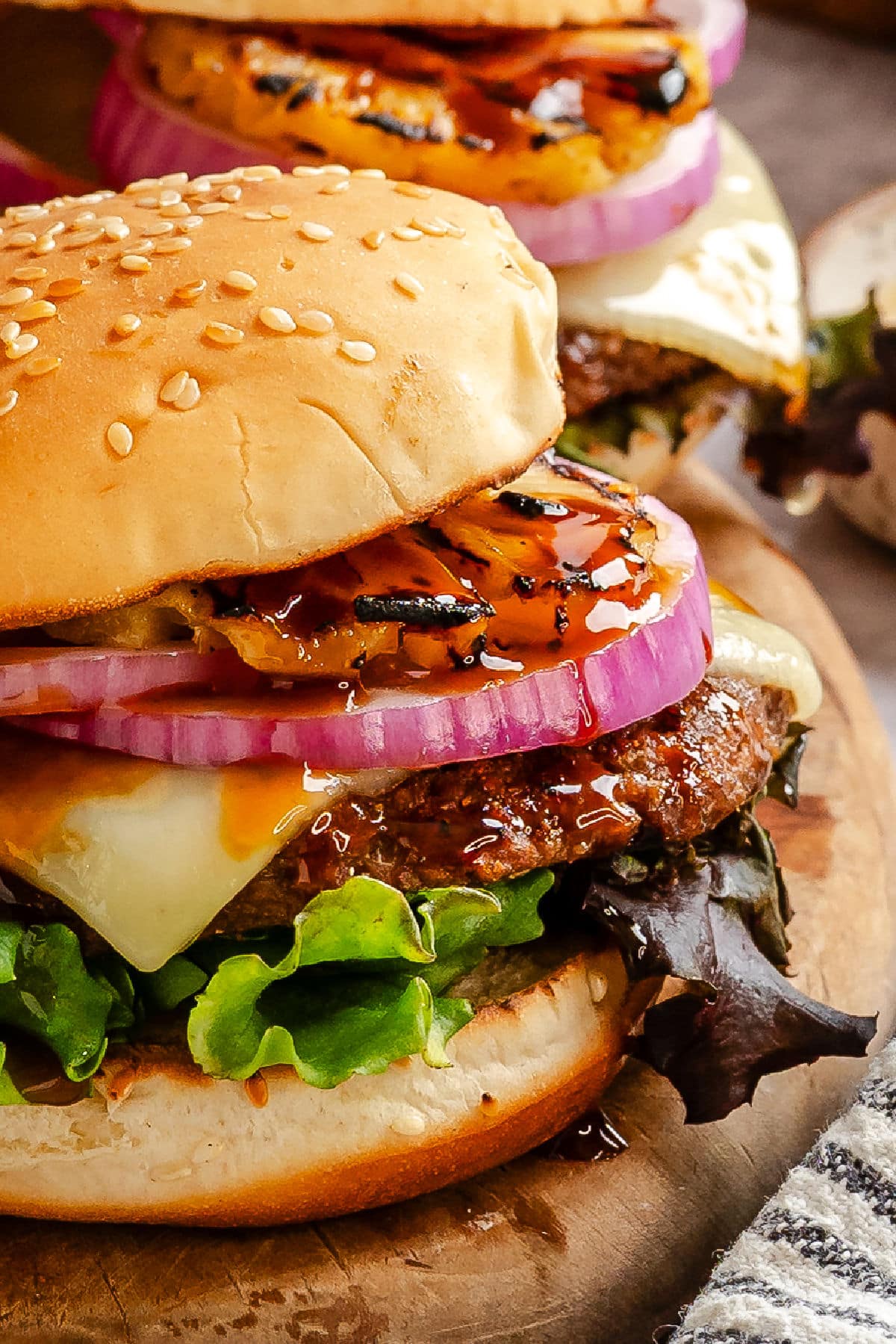 Close up of an aloha burger next to another burger.
